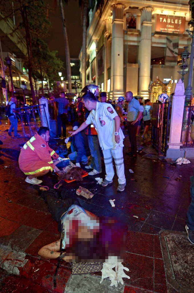 Thai rescue workers help the injured after a bomb exploded outside a religious shrine in central Bangkok late on August 17, 2015 killing at least 10 people and wounding scores more.  Body parts were scattered across the street after the explosion outside the Erawan Shrine in the downtown Chidlom district of the Thai capital.         AFP PHOTO / PORNCHAI KITTIWONGSAKUL        (Photo credit should read PORNCHAI KITTIWONGSAKUL/AFP/Getty Images)